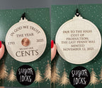 Front and back of a double-sided 2025 penny keepsake wooden ornament with engraved historical wording