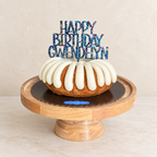 Personalized Happy Birthday Gwendelyn multicolor glitter acrylic cake topper on a white birthday cake