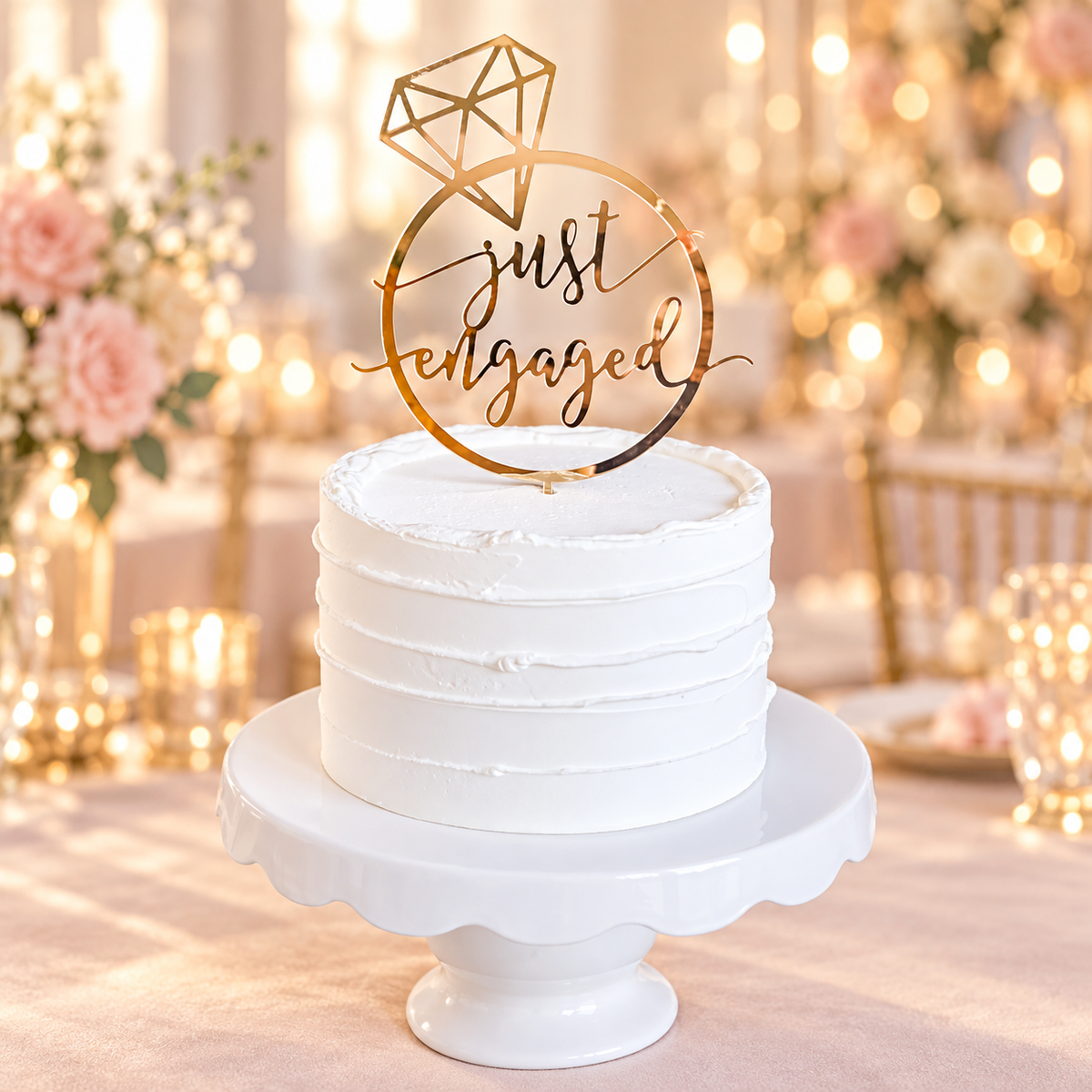 Gold mirrored Just Engaged ring cake topper displayed on a white cake
