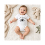 Smiling baby wearing white First Edition Published 2026 book baby bodysuit