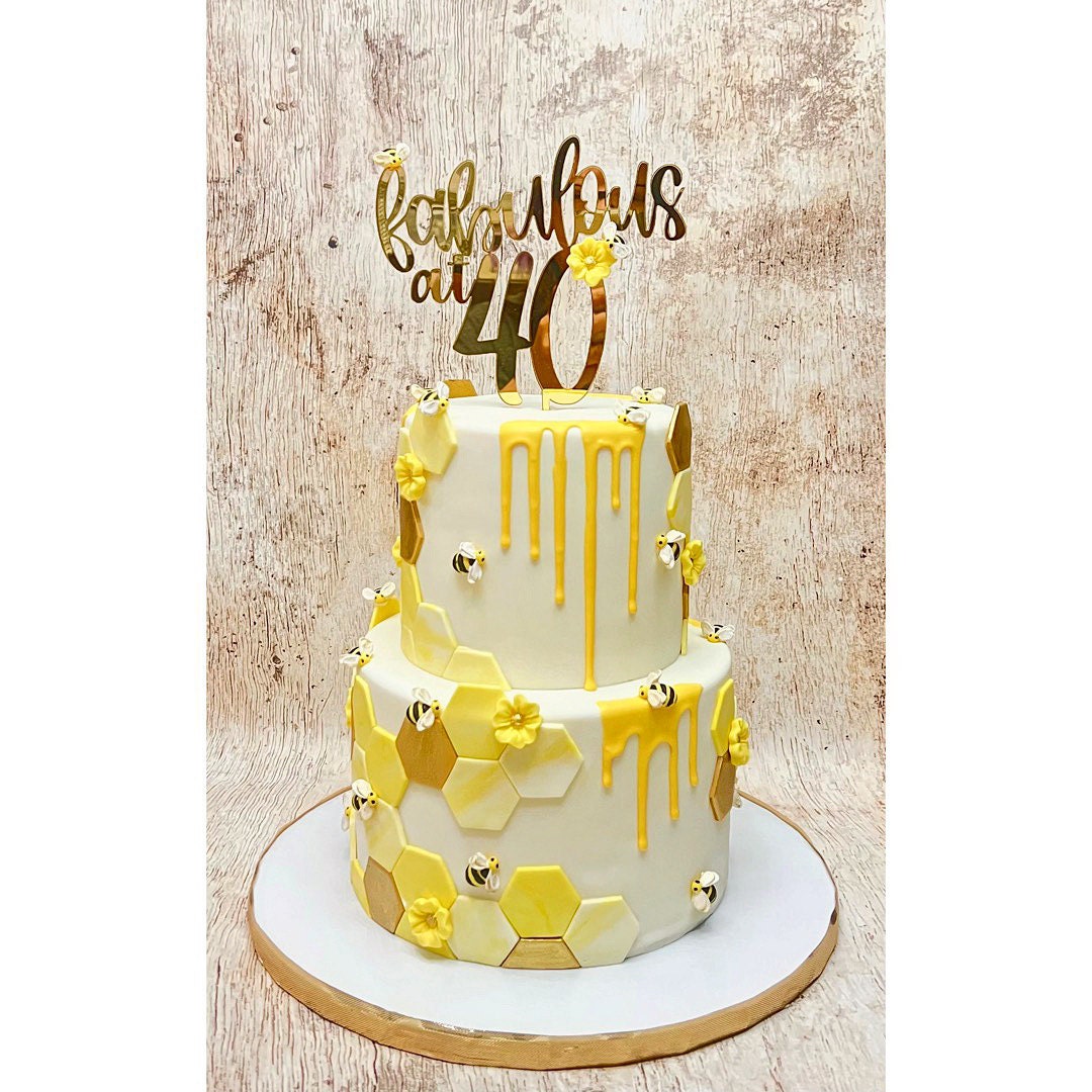 Fabulous at 40 gold mirrored acrylic cake topper on a white birthday cake